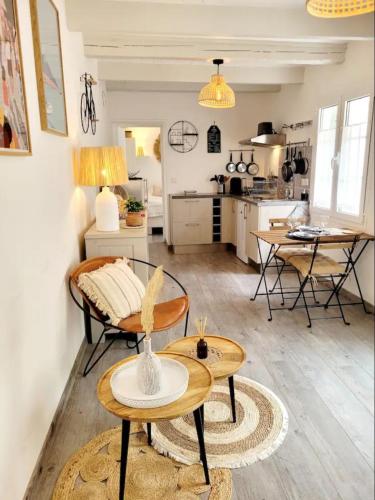 un salon avec une table et une cuisine dans l'établissement Appartement raffiné près de la mer et des commerces, à La Flotte