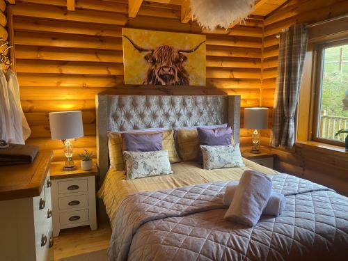 a bedroom with a bed with a picture of a bull at The Farmers den lodge at River Garry Lodges in Bridge of Tilt