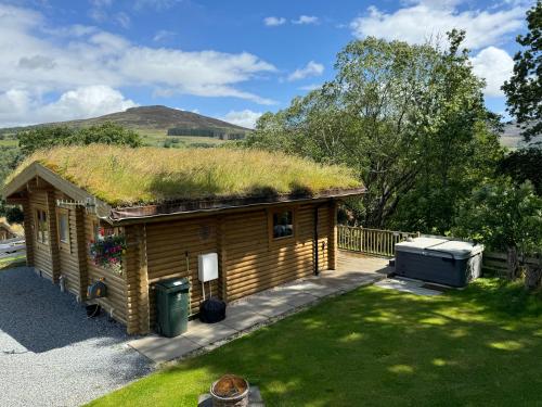 a log cabin with a grass roof at The Farmers den lodge at River Garry Lodges in Bridge of Tilt