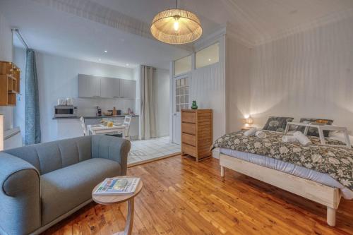 Cet appartement comprend une chambre avec un lit et un canapé ainsi qu'une cuisine. dans l'établissement Roi Humbert II - Centre-Ville - Caserne de Bonne, à Grenoble