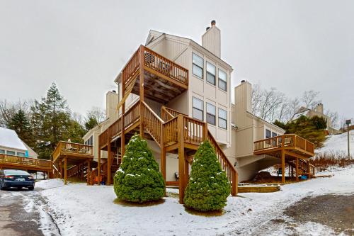 a large house with a deck in the snow at Jeffrey Lane Condos in Thayerville