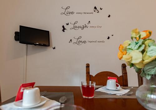 a table with a vase of flowers and a tv at La Fortezza Exclusive - Spazio e Relax in Centro in Livorno
