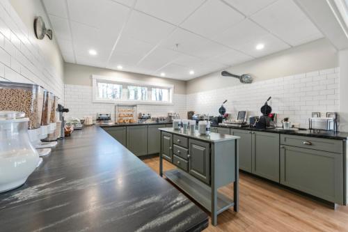 a large kitchen with gray cabinets and a counter at Country Inn at Camden Rockport in Rockport
