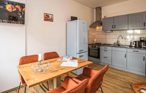 マルヒョーにある1 Bedroom Amazing Apartment In Malchowのキッチン(木製テーブル、椅子、冷蔵庫付)