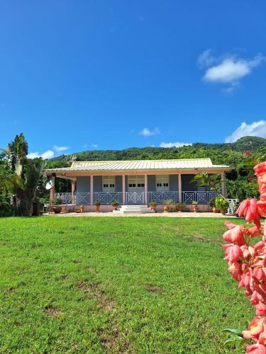 a house with a green roof and a yard at Le Nid Créole - Plage à 10min, WIFI, Jardin, TV in Le Marin