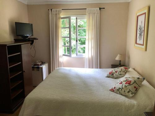a bedroom with a bed with two pillows and a window at Hotel Fazenda São Francisco in Cunha