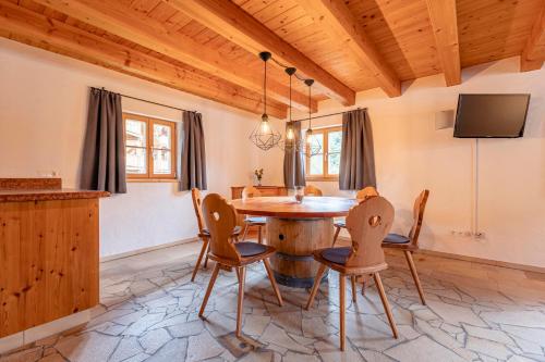 a dining room with a wooden table and chairs at Alm Chalet Grosseck in Mariapfarr