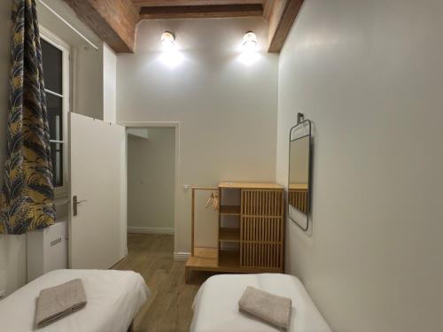 a room with two beds and a mirror at Presqu'ile Saint Nizier coeur de Lyon classé 4* in Lyon