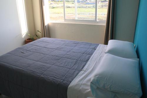 a bed in a bedroom with a window at Cómoda y Acogedora Casa cerca de Av Torreón Nuevo in Morelia