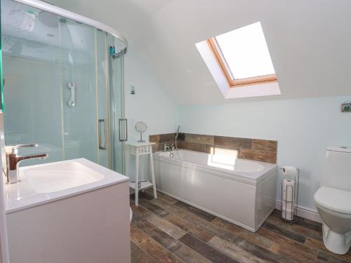 Un baño con bañera, lavabo y ducha. en The Old Stable, en Hull