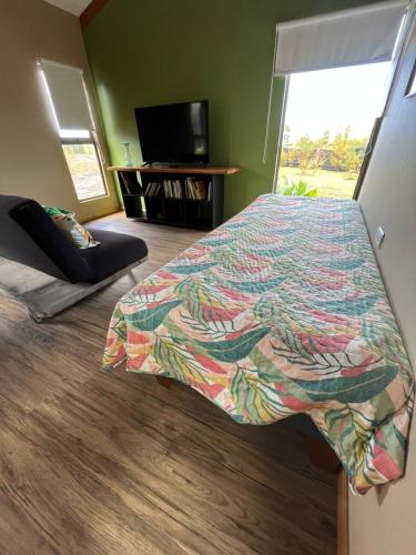 a bedroom with a bed with a colorful comforter at Refugio Rivarahi in Hanga Roa