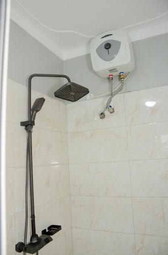 a shower with a shower head on the wall at Big Thrills Hotel and Suites Kampala in Kampala