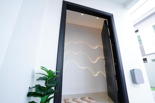 a mirror in a room with a plant at Desaru 918 Arcadia villa in Kangkar Chemaran