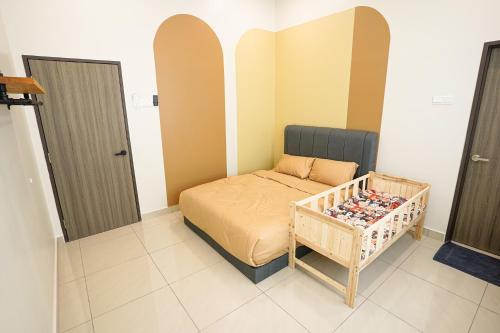 a small bedroom with a bed and a crib at Desaru 918 Arcadia villa in Kangkar Chemaran