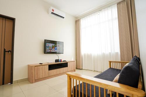 a living room with a couch and a tv in a room at Desaru 918 Arcadia villa in Kangkar Chemaran