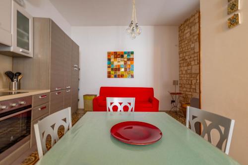 a kitchen with a table with a red plate on it at Antiche Mura Apartments "Nel Cuore della Puglia"bivani, cucina, terrazzo in Turi