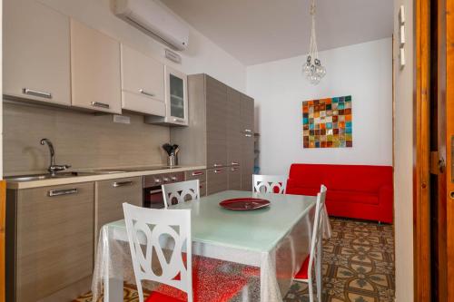 a kitchen with a table and chairs and a red couch at Antiche Mura Apartments "Nel Cuore della Puglia"bivani, cucina, terrazzo in Turi