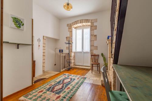 a living room with a door and a rug at Antiche Mura Apartments "Nel Cuore della Puglia"bivani, cucina, terrazzo in Turi