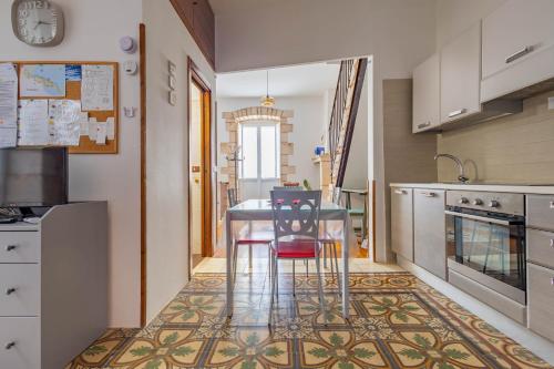 a kitchen with a table and two stools at Antiche Mura Apartments "Nel Cuore della Puglia"bivani, cucina, terrazzo in Turi