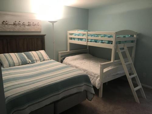a bedroom with two bunk beds and a lamp at Papa & Gigi's Lake Front Home in Port Clinton