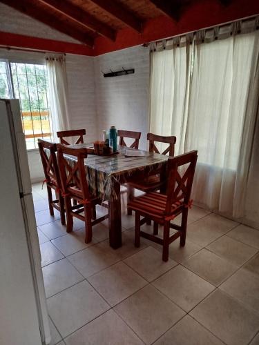 a dining room table with chairs and a table at Cabañas del Puente - Rio Grande San Luis in La Bajada