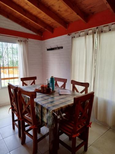 a wooden table in a room with chairs around it at Cabañas del Puente - Rio Grande San Luis in La Bajada