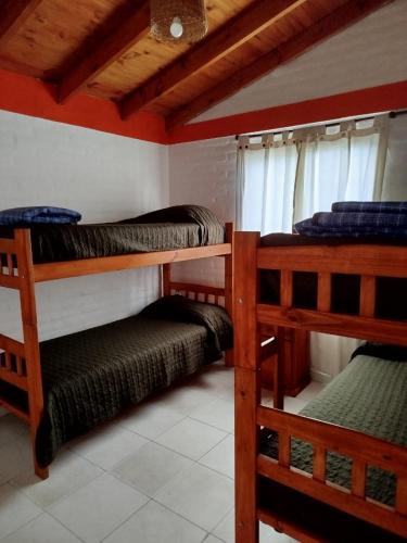 a room with three bunk beds in a house at Cabañas del Puente - Rio Grande San Luis in La Bajada