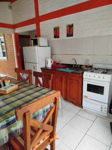 a kitchen with a table and a stove top oven at Cabañas del Puente - Rio Grande San Luis in La Bajada