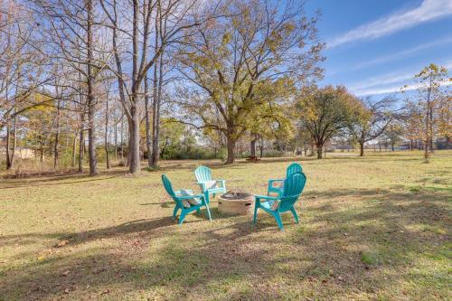 three chairs and a fire hydrant in a park at Nature Lovers Haven with Fire Pit in Pangburn! in Pangburn