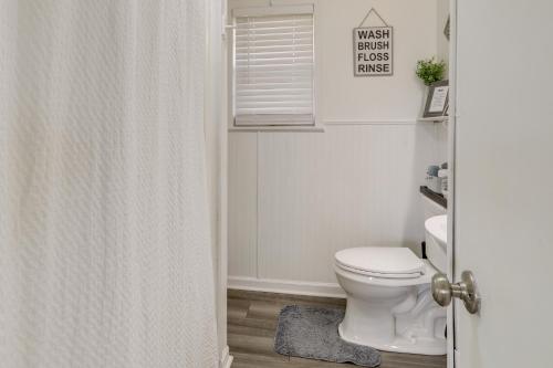 a white bathroom with a toilet and a window at Nature Lovers Haven with Fire Pit in Pangburn! in Pangburn