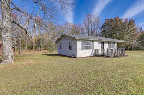 a small white house in a yard with a tree at Nature Lovers Haven with Fire Pit in Pangburn! in Pangburn