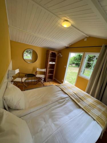 a bedroom with a large white bed and a table at Solröje in Simrishamn