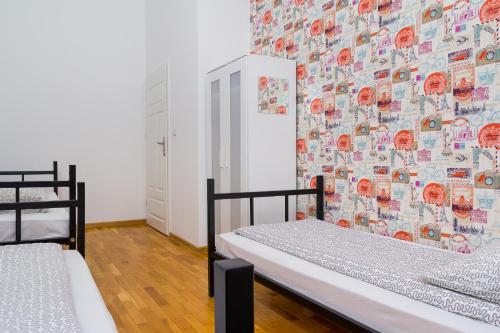 two beds in a room with a wall covered in stickers at Retro Hostel in Poznań