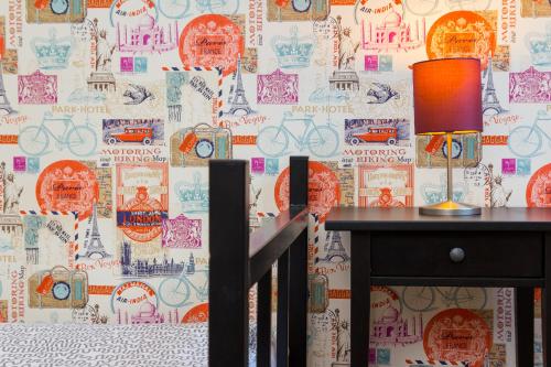 a table with a lamp on it in front of a wall at Retro Hostel in Poznań