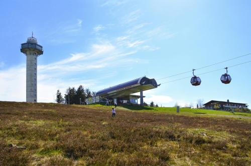 a person standing in a field next to a ski lift at Fewo Willingenliebe Meinecardplus in Willingen