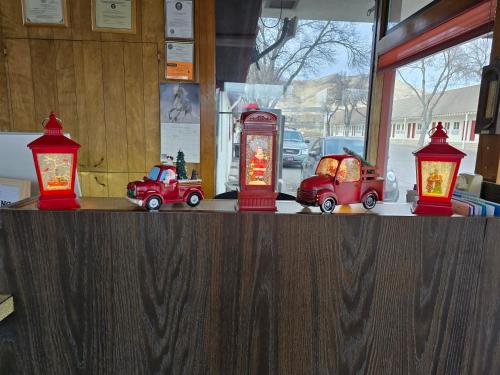 three red toy cars sitting on a counter with lights at Scott Shady Court Motel in Winnemucca