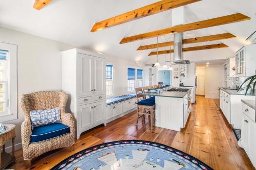 a kitchen with white cabinets and a table and chairs at Large waterfront home with direct beach access in Dennis