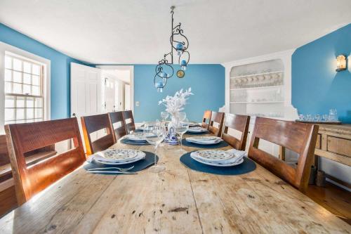 a dining room with a wooden table and blue walls at Large waterfront home with direct beach access in Dennis