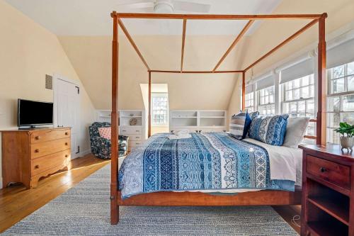 a bedroom with a canopy bed and a television at Large waterfront home with direct beach access in Dennis