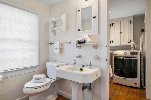 a white bathroom with a sink and a toilet at Large waterfront home with direct beach access in Dennis