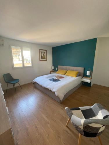 une chambre avec un grand lit et une chaise dans l'établissement Maison individuelle avec piscine et SPA, à Afa