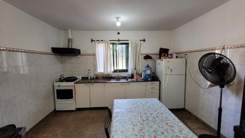 a small kitchen with a refrigerator and a sink at Casa Cedro Azul II in Villa Carlos Paz