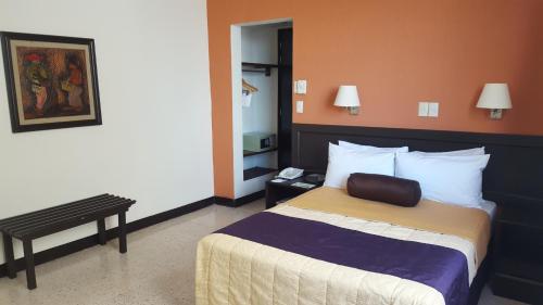 a hotel room with a bed and a bench at Hotel Valgrande in Coatzacoalcos