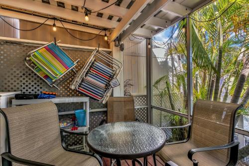 a balcony with a table and chairs and a window at Slo M'Ocean in Anna Maria