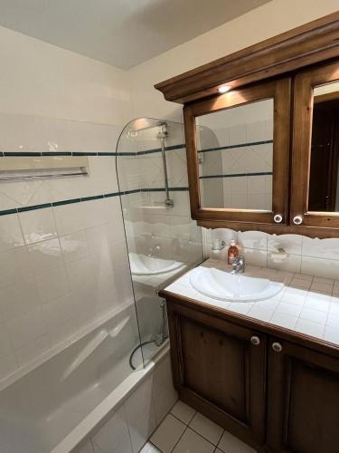 une salle de bain avec un lavabo, une douche et une baignoire dans l'établissement Résidence Les Fermes du Soleil - maeva Home - Appartement 3 pièces 6 personnes - Prestige MAE-4281, à Arâches-la-Frasse
