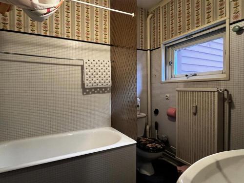 a bathroom with a tub and a toilet and a window at Résidence Bero Bisto - maeva Home - Studio 4 personnes - Confort MAE-1951 in La Mongie