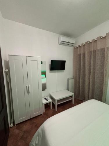 1 dormitorio con 1 cama, armario y TV en OPUNTIA DELL'ETNA BIKE HOUSE, en Mascalucia