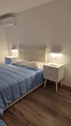 a bedroom with a bed and a nightstand with a blue blanket at A.l. KATEKERO in Costa Nova