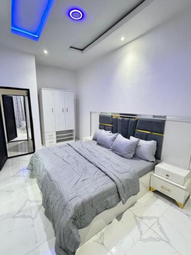 a bedroom with a large bed with a blue ceiling at Sunny Service Apartment in Lagos