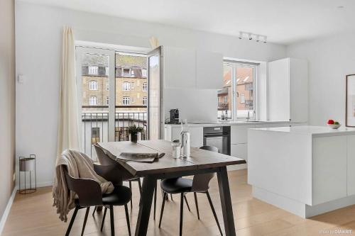 a kitchen and dining room with a table and chairs at Bright & Inviting Apartment Near ARoS Art Museum in Aarhus